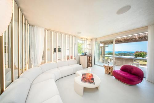 a living room with a white couch and a red chair at Destino Five Ibiza - 5-Star Grand Luxe Resort in Talamanca