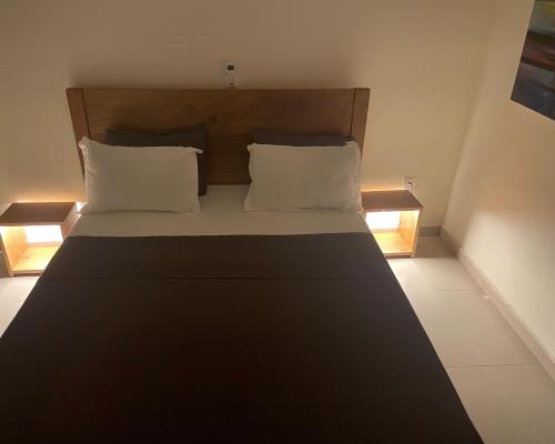 a bedroom with a bed with two pillows at Hôtel Restaurant Lounge Madiana Plage in Grand-Bassam