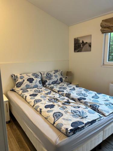 a bedroom with a bed with a blue and white comforter at Seaside in Bovenkarspel