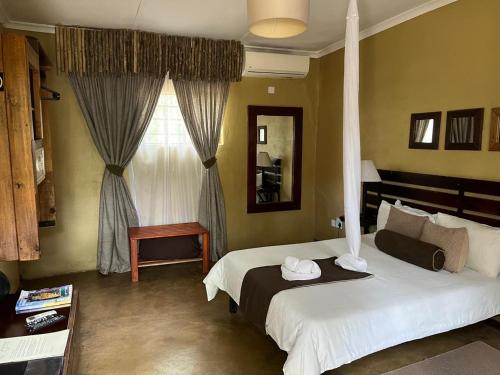 a bedroom with two beds and a window at Phokoje Bush Lodge in Selebi-Pikwe