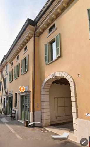 aige building with an archway and a garage at Casa Frida, penthouse on the lake in Lonato del Garda