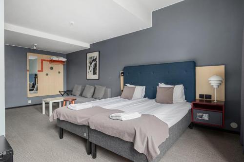a bedroom with a large bed with a blue wall at Best Western Hotel Norrkoping City in Norrköping