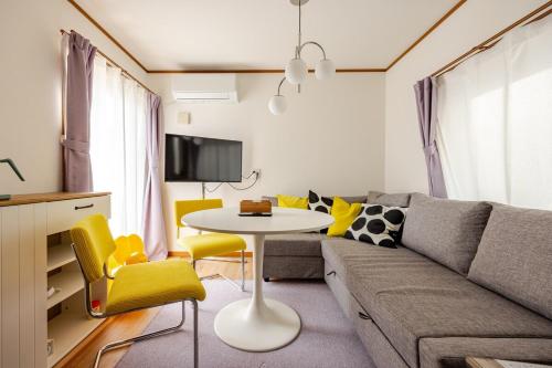 a living room with a couch and a table at K's House Mizumoto in Tokyo