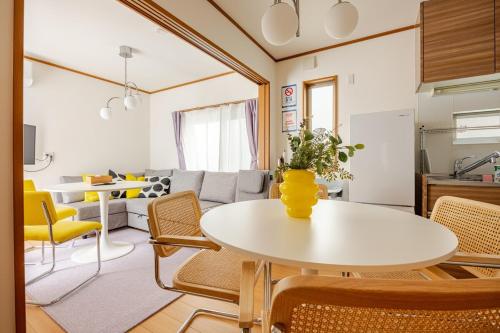 a living room with a white table and chairs at K's House Mizumoto in Tokyo