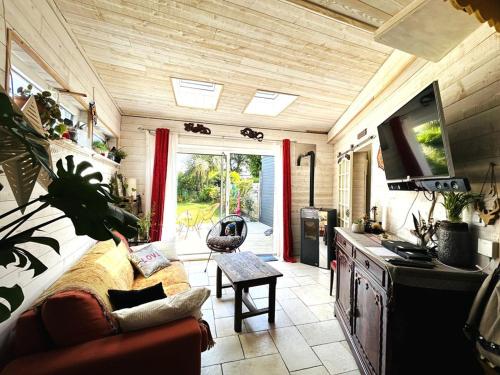 un salon avec un canapé et une télévision dans l'établissement Maison 2 pièces 4 personnes, résidence très calme à 5 mn des plages - Wifi, à Guidel