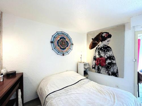 une chambre avec une photo d'une femme sur le mur dans l'établissement Maison 2 pièces 4 personnes, résidence très calme à 5 mn des plages - Wifi, à Guidel