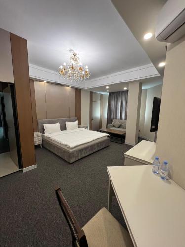 a hotel room with a bed and a chandelier at Mountain View Residence Hotel in Almaty