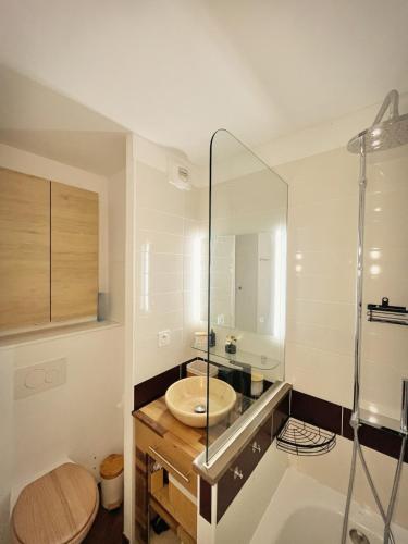 une salle de bain avec un lavabo et une douche en verre dans l'établissement La Perle Blanche, à Saint-Raphaël