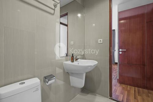 a bathroom with a sink and a toilet and a mirror at Halia by Kozystay - Pondok Indah in Jakarta