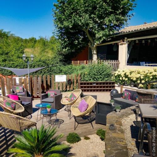 une terrasse en bois avec des chaises et des tables dans l'établissement Camping Domaine de la GAUTIERE, à La Penne-sur-lʼOuvèze