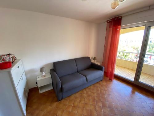 un salon avec un canapé et une grande fenêtre dans l'établissement Plage et commerces à 300 m tout à pied, idéal vacances, à Saint-Elme
