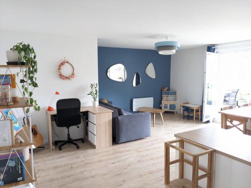 un salon avec un mur d'accent bleu dans l'établissement Appartement familial piscine - Proche gare et tram, à Bordeaux