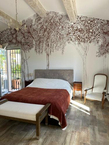 - une chambre avec un lit et des arbres sur le mur dans l'établissement Maison provençale Antibes, à Antibes