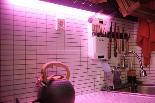 uma cozinha de azulejos rosa com uma pia e um vaso em Abrakadabra Manshon em Timuran