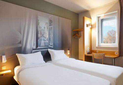 Ένα ή περισσότερα κρεβάτια σε δωμάτιο στο B&B HOTEL Aix-en-Provence Pont de l'Arc