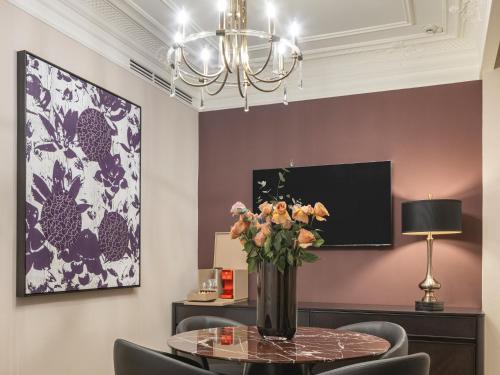 a dining room with a table with a vase of flowers at Komana Hotel Binbirdirek in Istanbul