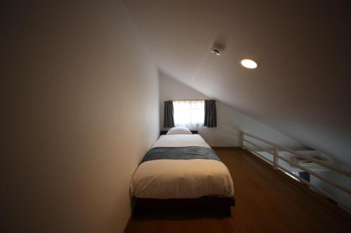 a small bedroom with a bed in a attic at goom Monthly Nakasu Maxim in Fukuoka