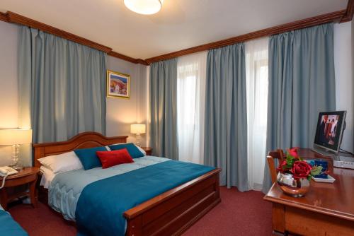 una camera d'albergo con letto, scrivania e finestre di Villa Meri a Trogir