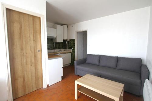 un salon avec un canapé et une table dans l'établissement Studio Cabine en frond de mer, à Canet
