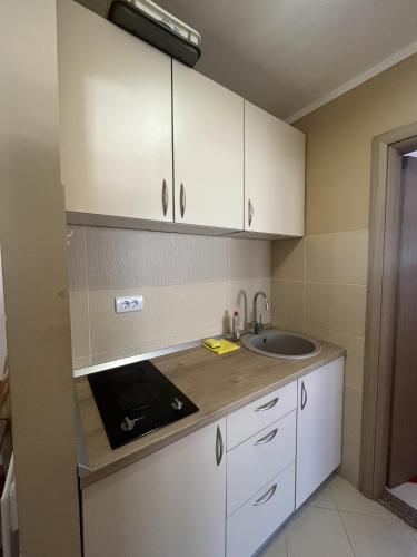 a kitchen with white cabinets and a sink at Lido MONTENEGRO Bijela in Bijela