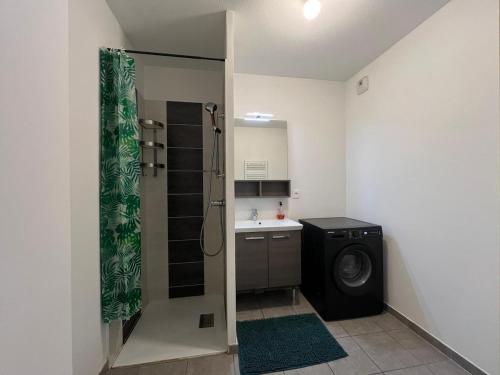 une salle de bain avec douche et machine à laver dans l'établissement T2 moderne avec terrasse, proche de Lyon, à Vaulx-en-Velin