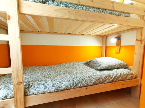 a bunk bed in a room with an orange wall at La belle histoire in Montignac