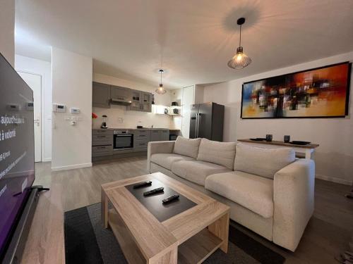 un salon avec un canapé et une table dans l'établissement T2 moderne avec terrasse, proche de Lyon, à Vaulx-en-Velin