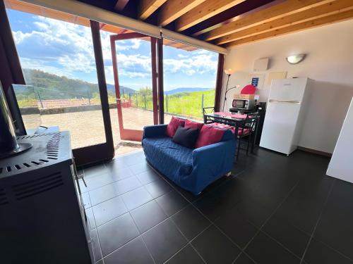 a living room with a blue couch and a kitchen with a view at Casa de Labrujó - Vista Panorâmica e Tranquilidade in Ponte de Lima