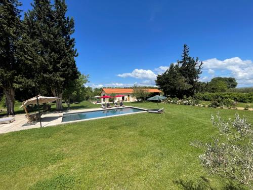 une cour avec une piscine et une maison dans l'établissement Mas Etienne Piscine&Nature Saint-Rémy Conciergerie, à Saint-Rémy-de-Provence