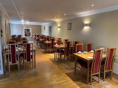una sala da pranzo con tavoli e sedie in legno di Harmony Inn - Glena House a Killarney