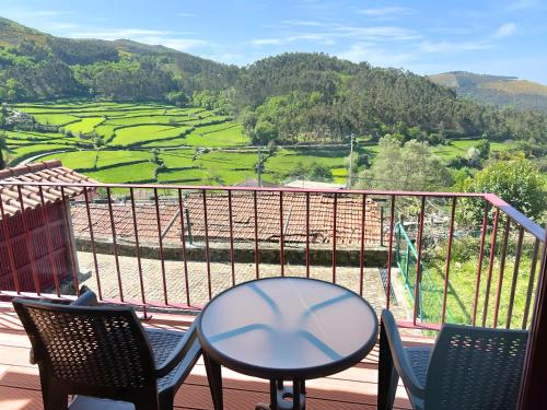 a table and chairs on a balcony with a view at Casa de Labrujó - Vista Panorâmica e Tranquilidade in Ponte de Lima