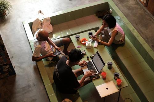 a group of people sitting at a table with a laptop at Abrakadabra Manshon in Timuran