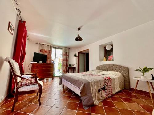 une chambre avec un lit, une chaise et une télévision dans l'établissement La Belle de Castille, à Argilliers