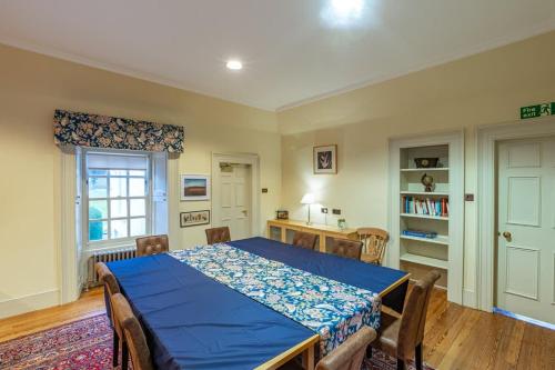 a bedroom with a blue bed and a table at Penninghame Estate - Stewart Apartment in Challoch