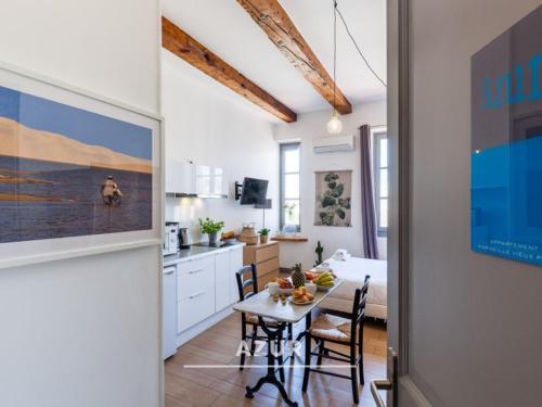 une cuisine et une salle à manger avec une table dans une pièce dans l'établissement Les Cocons - 8 appartements à 100m du Vieux Port, à Marseille