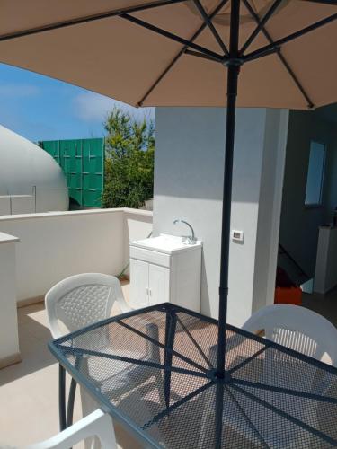 a table and chairs with an umbrella on a balcony at Newfaro2 in Taranto