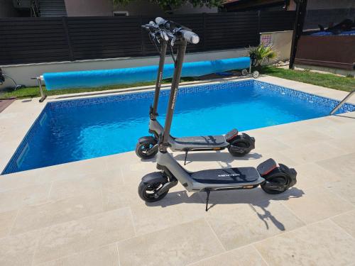 a scooter parked next to a swimming pool at Villa Jana in Kolan