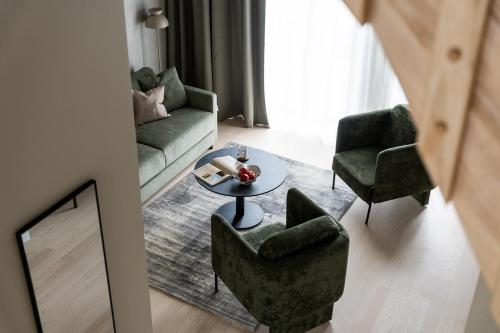 a living room with a couch and chairs and a table at Vander Aparthotel Inre Hamnen in Norrköping