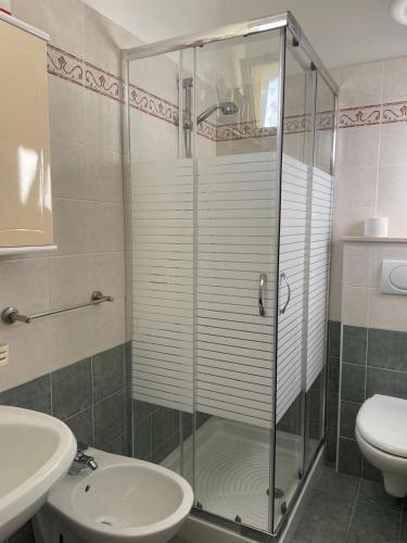 a bathroom with a shower and a toilet and a sink at Luxemburg in Caorle