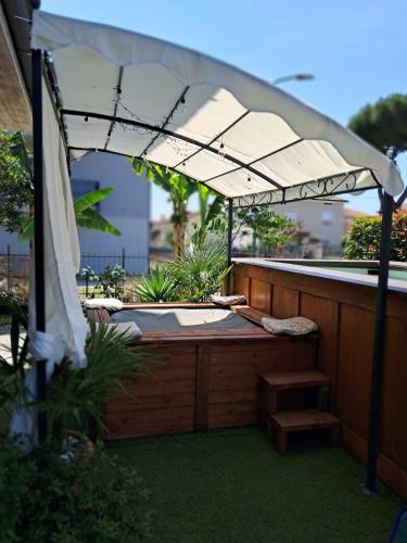 an outdoor hot tub with an umbrella on a patio at Sakura B&B Franciacorta in Cologne
