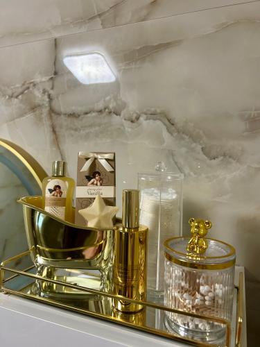 a gold tray with a bottle of perfume and a candle at MAK apartment in Kaštela
