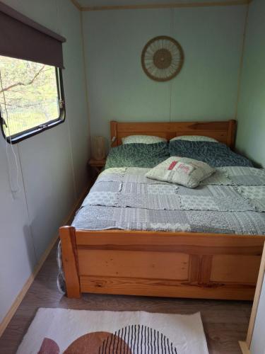 ein Schlafzimmer mit einem Holzbett und Kissen darauf in der Unterkunft Domeczek in Sulęczyno