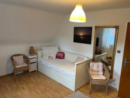 a small bedroom with a bed and two chairs at Apartment für zwei in Isenbüttel