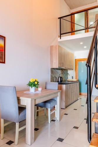 a kitchen and dining room with a wooden table and chairs at Roan Apartments in Sarandë
