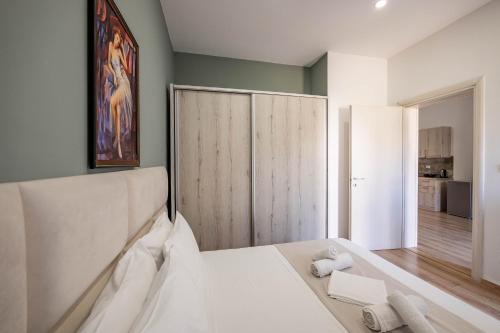 a bedroom with a white bed and a large closet at Roan Apartments in Sarandë