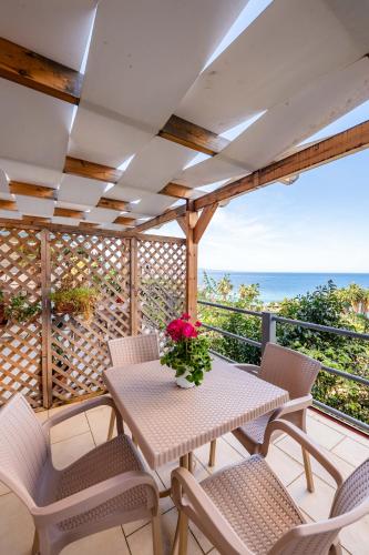 a patio with a table and chairs and the ocean at Roan Apartments in Sarandë