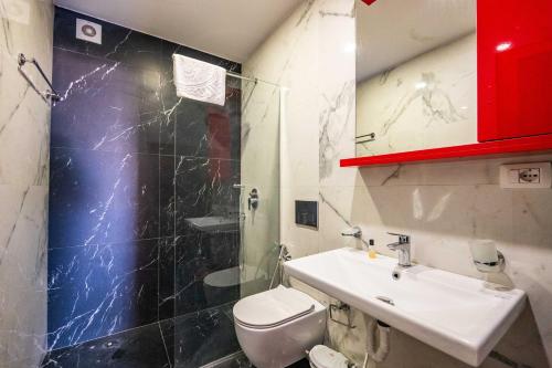 a bathroom with a white toilet and a sink at Roan Apartments in Sarandë