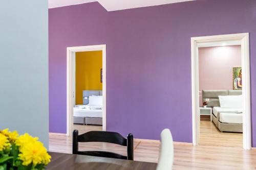 a dining room with purple walls and a mirror at Roan Apartments in Sarandë