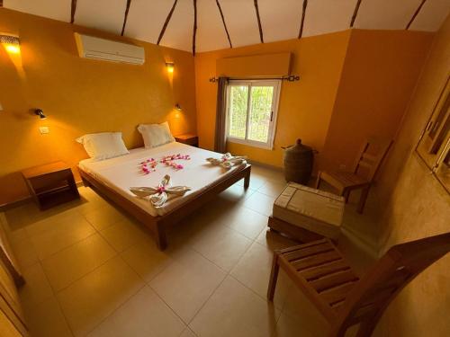 a bedroom with a bed and a table with flowers on it at Agence Adjana Resort - Résidence du Port 3 in Sali Tapé