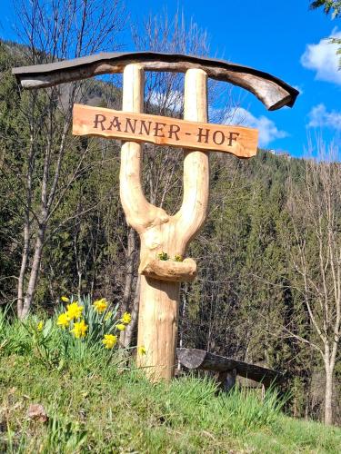 a wooden sign for a ranger hut in a field at Waldpension Ranner 